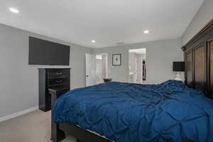 Bedroom featuring light carpet and ensuite bath