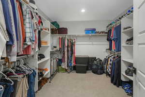 Walk in closet with light colored carpet