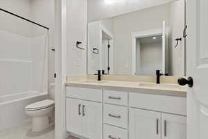 Full bathroom featuring toilet, tile patterned flooring, shower / bathing tub combination, and vanity