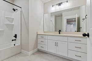 BasementBathroom featuring vanity and washtub / shower combination