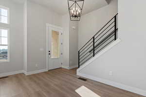 Entryway featuring light hardwood / wood-style floors, a chandelier, and a healthy amount of sunlight