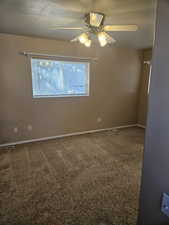 Carpeted primary bedroom featuring ceiling fan and a textured ceiling