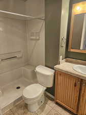 Primary Bathroom featuring toilet, vanity, tile patterned flooring, and a shower