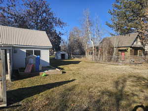 View of back yard with a storage unit