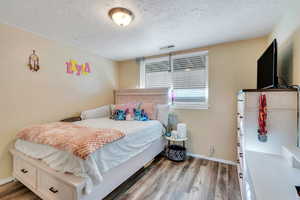 Bedroom featuring wood-type flooring and a textured ceiling