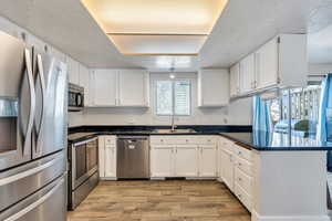 Kitchen featuring sink, white cabinetry, and appliances with stainless steel finishes