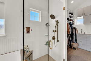 Bathroom with plenty of natural light, shower with separate bathtub, and vaulted ceiling