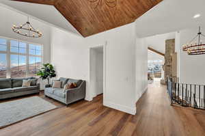 Living room featuring a notable chandelier, high vaulted ceiling, a healthy amount of sunlight, and wooden ceiling