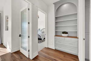 Hallway featuring built in features and light wood-type flooring