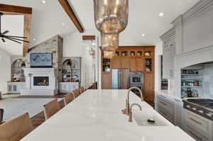 Kitchen with light stone countertops, pendant lighting, sink, and stainless steel appliances