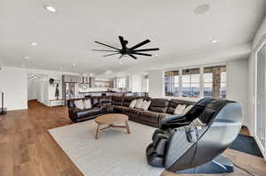 Living room with ceiling fan and light wood-type flooring