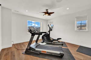 Workout room with ceiling fan and hardwood / wood-style floors