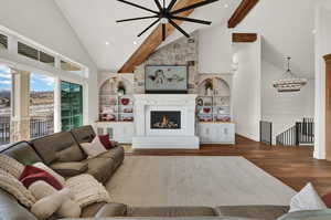 Living room featuring built in shelves, hardwood / wood-style flooring, a chandelier, and a fireplace