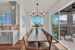 Dining space with light hardwood / wood-style floors, sink, a mountain view, and a chandelier