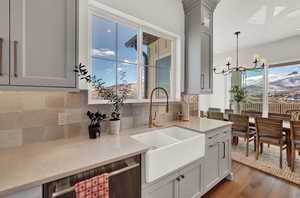 Kitchen with pendant lighting, sink, dark wood-type flooring, tasteful backsplash, and a mountain view