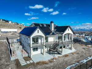 Back of house featuring solar panels and a patio