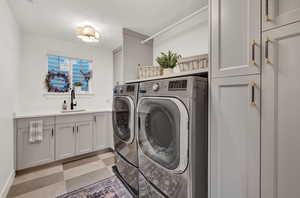 Clothes washing area with sink, washing machine and clothes dryer, and cabinets