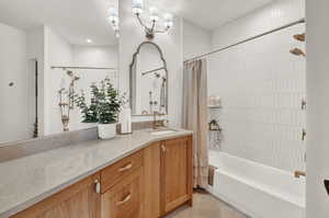 Bathroom with shower / bath combination with curtain, tile patterned flooring, and vanity