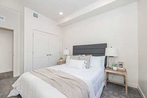 Carpeted bedroom with a closet