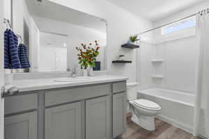 Full bathroom featuring shower / bath combo with shower curtain, wood-type flooring, toilet, and vanity