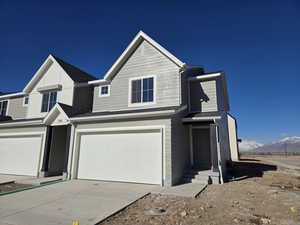 View of front of property with a garage and a mountain view