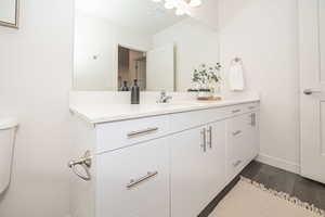 Bathroom featuring wood-type flooring, toilet, and vanity