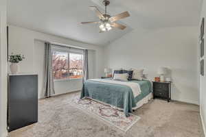 Primary Bedroom: Carpeted bedroom featuring vaulted ceiling and ceiling fan