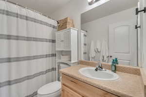 Bathroom with vanity, toilet, and a textured ceiling