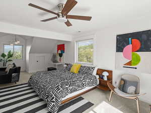 Carpeted bedroom with ceiling fan and vaulted ceiling