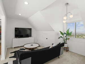 Living room with lofted ceiling and light colored carpet