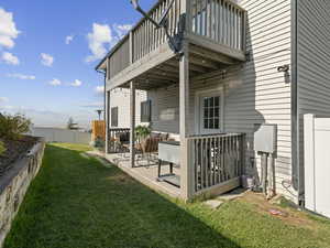 Rear view of property featuring a balcony, a yard, and a patio