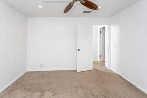 Empty room featuring ceiling fan and light colored carpet