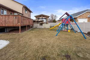 View of play area with a deck, a gazebo, and a lawn