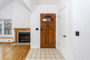 Foyer entrance featuring vaulted ceiling and light wood-type flooring