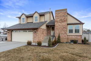 View of front of property featuring a garage and a front lawn