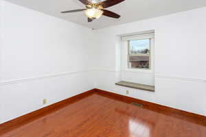 Spare room featuring wood-type flooring and ceiling fan