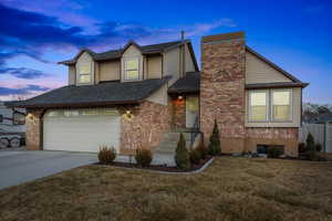 View of front of home featuring a garage and a yard