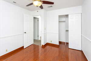 Unfurnished bedroom featuring ceiling fan, hardwood / wood-style floors, and a closet