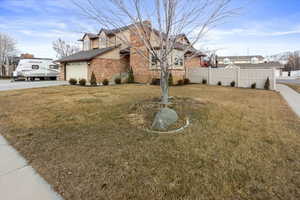 View of side of property with a garage and a lawn