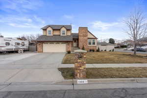 View of front of property featuring a garage and a front lawn with a large area for RV Parking.