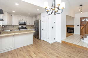 Kitchen with tasteful backsplash, sink, kitchen peninsula, pendant lighting, and stainless steel appliances