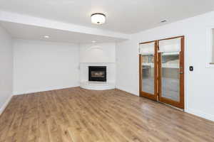 Unfurnished living room with a brick fireplace and light hardwood / wood-style flooring