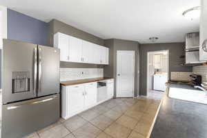 Kitchen with sink, white cabinets, stainless steel appliances, and washer / clothes dryer