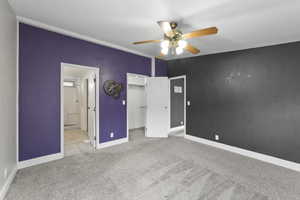 Unfurnished bedroom with ceiling fan, connected bathroom, a closet, and light carpet