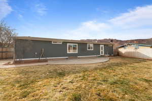 Back of house with a patio area and a yard