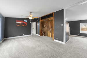 Unfurnished bedroom featuring light carpet, ceiling fan, and stainless steel refrigerator