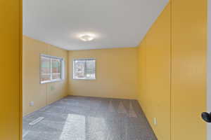 Carpeted spare room with a textured ceiling