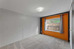 Carpeted empty room featuring a textured ceiling