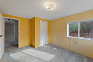 Unfurnished bedroom with light colored carpet and a closet