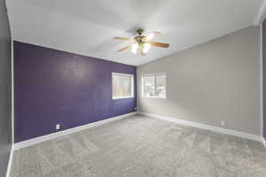 Unfurnished room featuring lofted ceiling, carpet floors, and ceiling fan